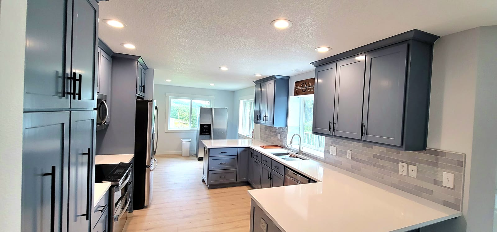 Remodeled kitchen with grey cabinets and wooden floors